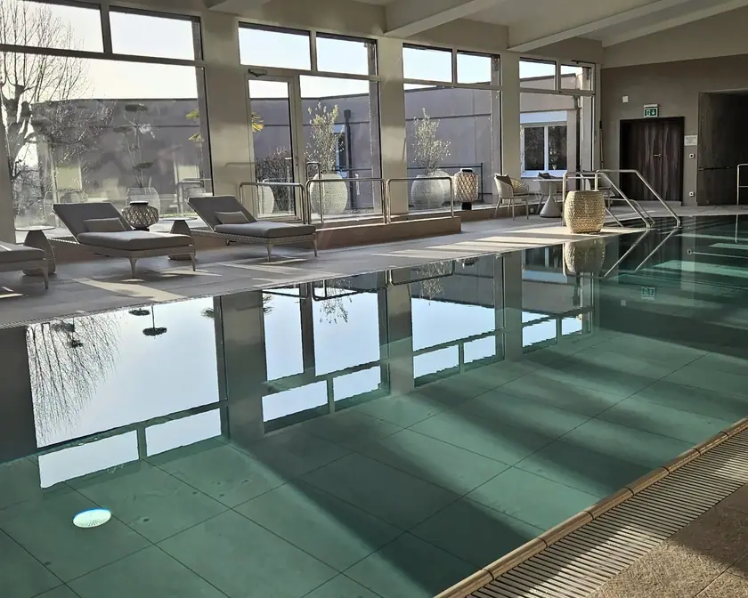 La piscine thérapeutique du Domaine, ses transats et ses grandes baies vitrées