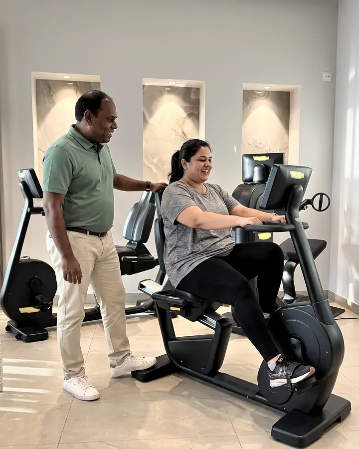 Jeune patiente pédalant sur un vélo semi-allongé, encouragée par un physiothérapeute